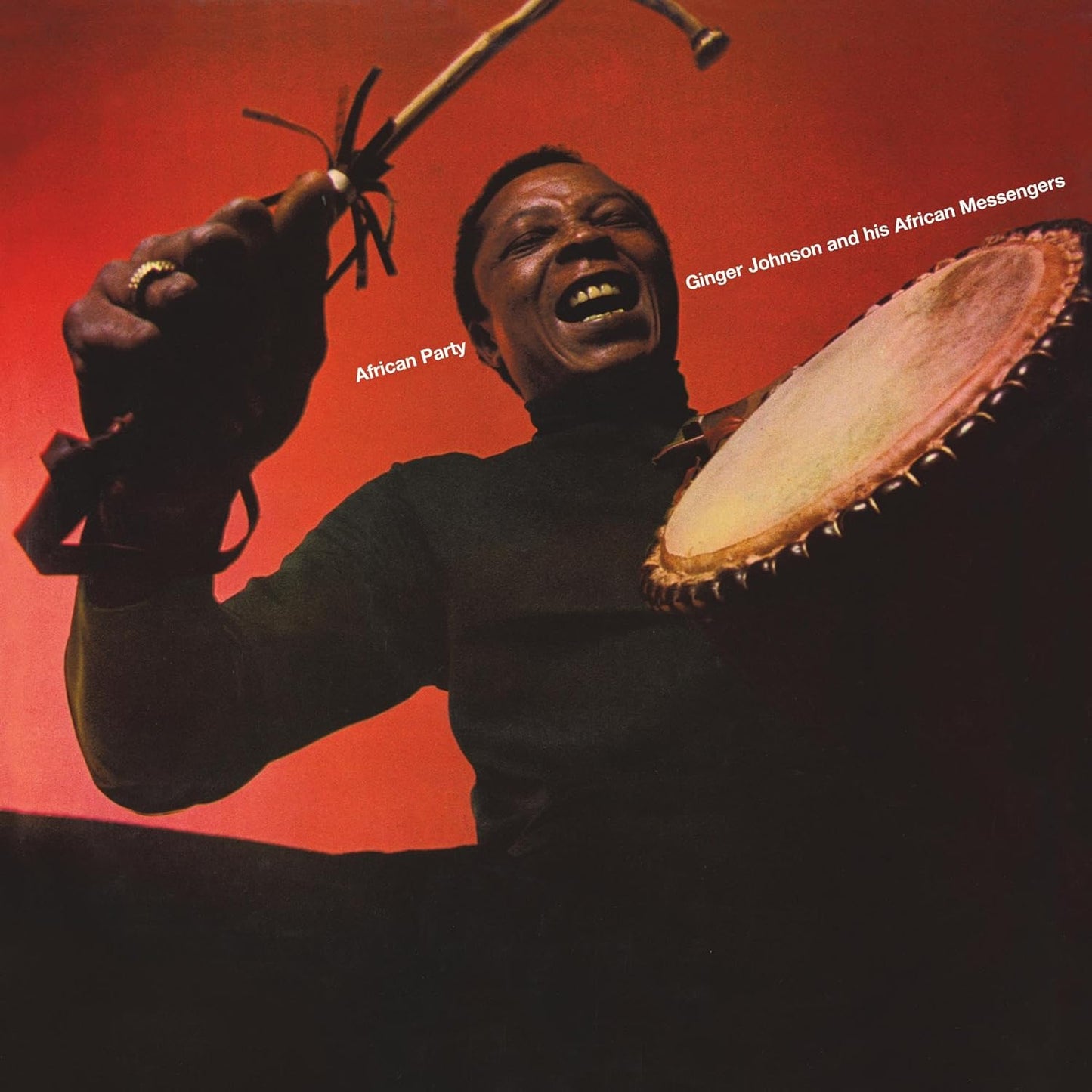 Ginger Johnson playing a large drum on a red album cover.