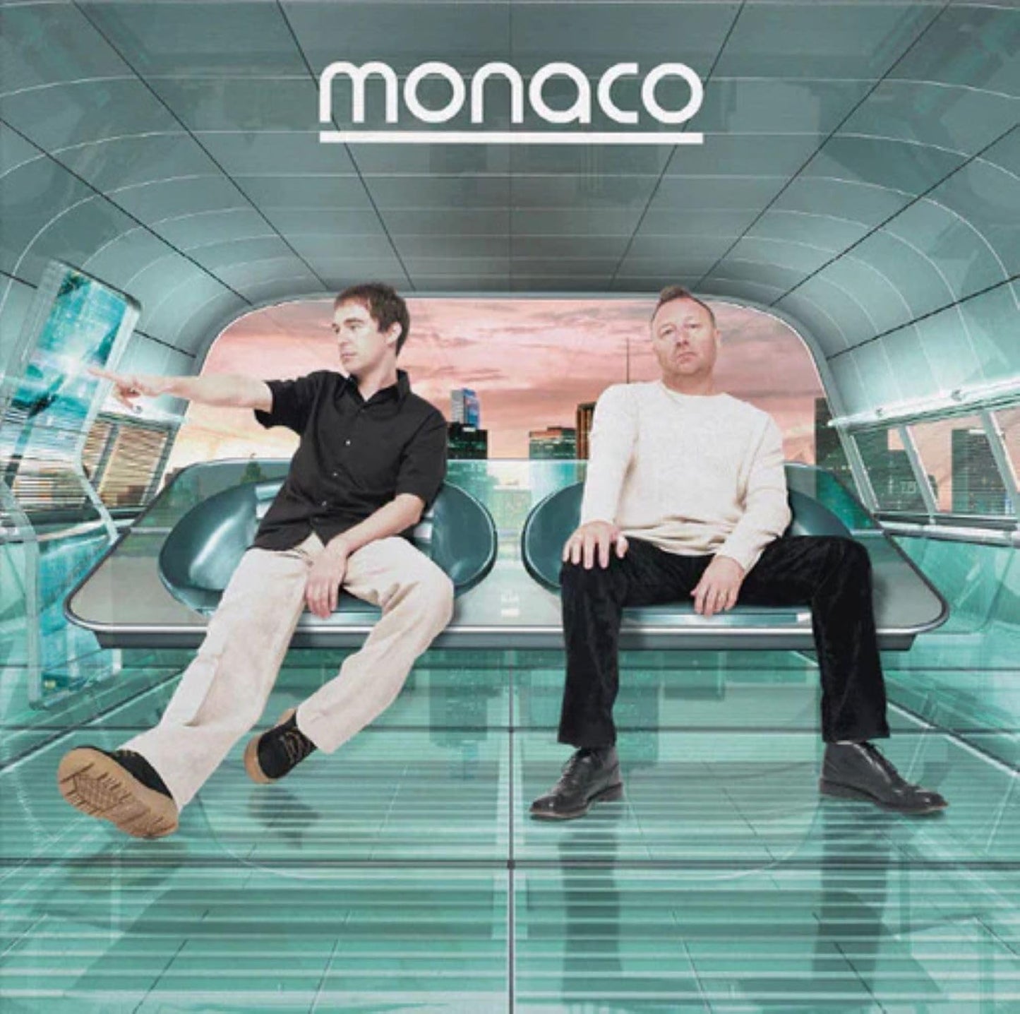 Two men sit on a futuristic bench overlooking a city skyline at sunset.