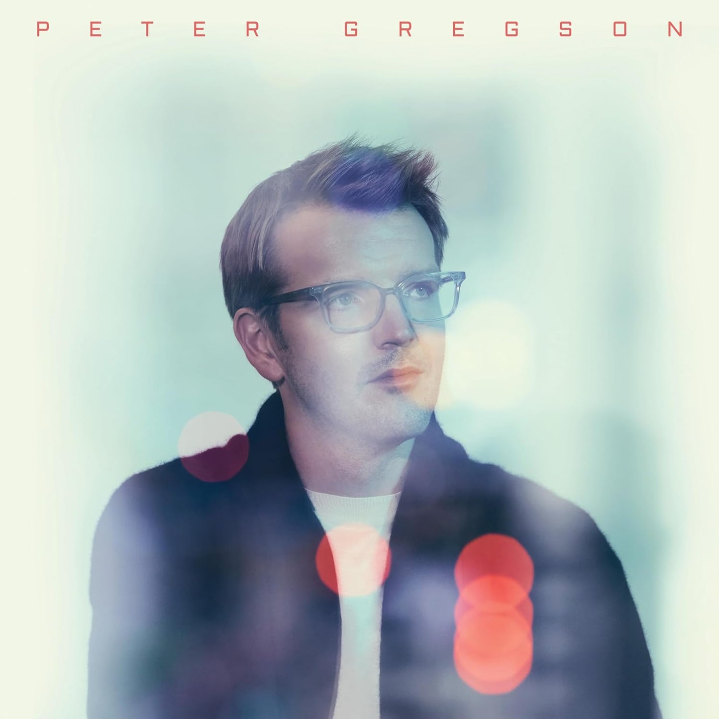 Portrait of Peter Gregson with blurred colorful lights in background.