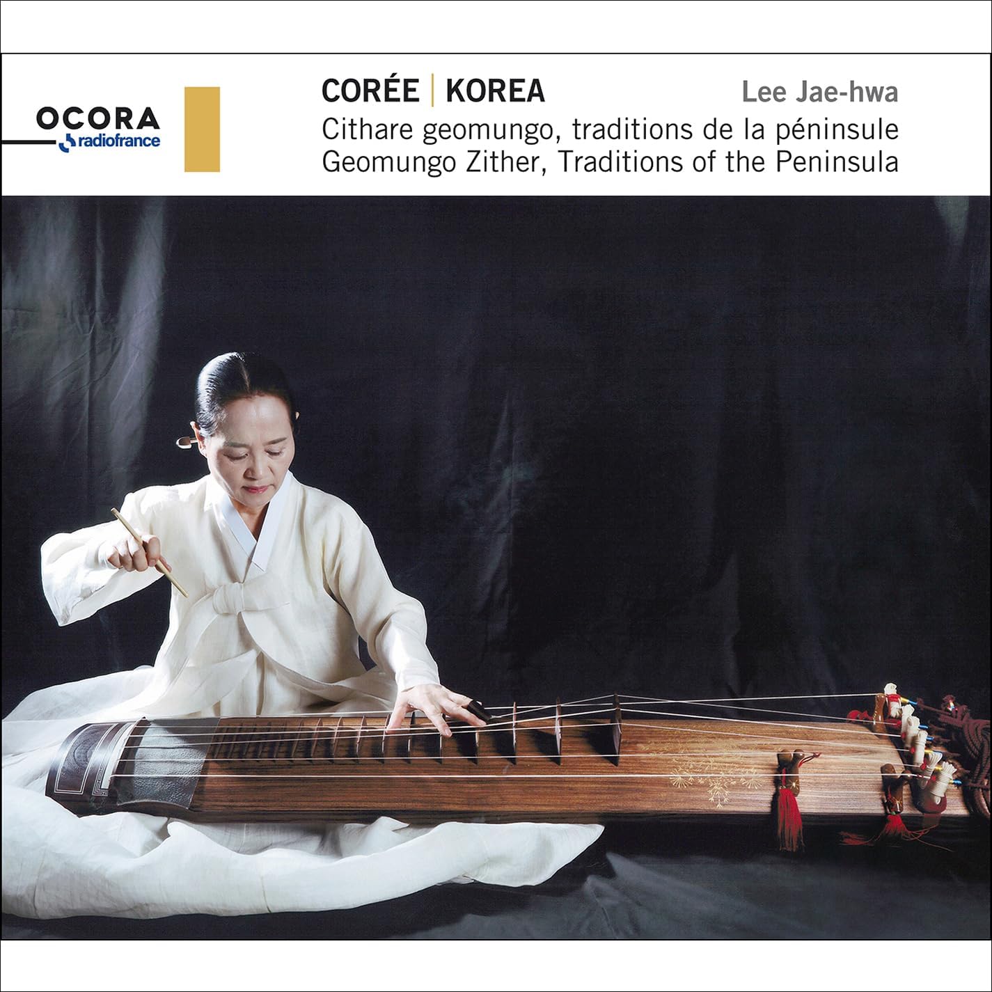 Woman playing a traditional Korean geomungo zither instrument.
