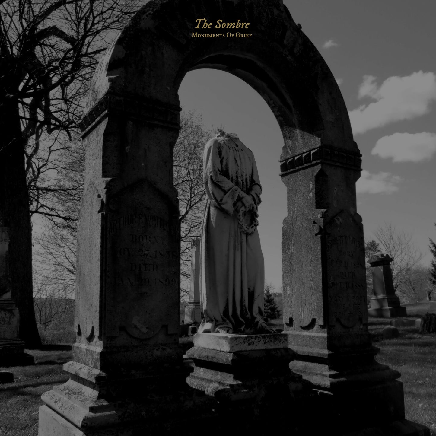 Black and white image of a headless statue in a cemetery archway.