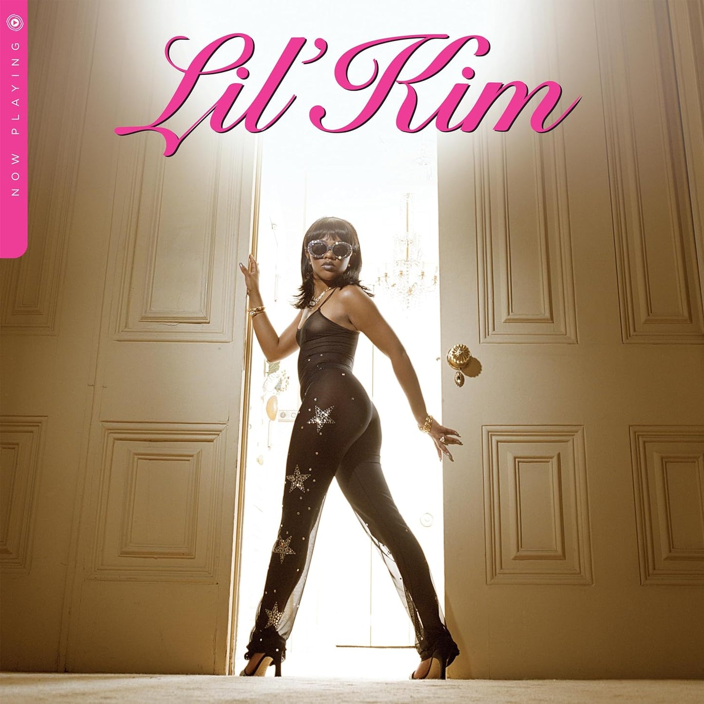 Lil' Kim album cover: artist in sparkly suit, doorway background.