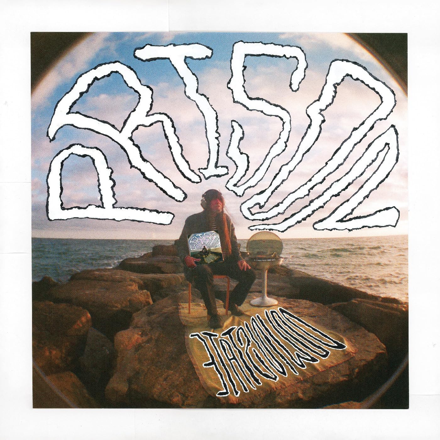 Vinyl album cover with a person seated on rocks by the sea.
