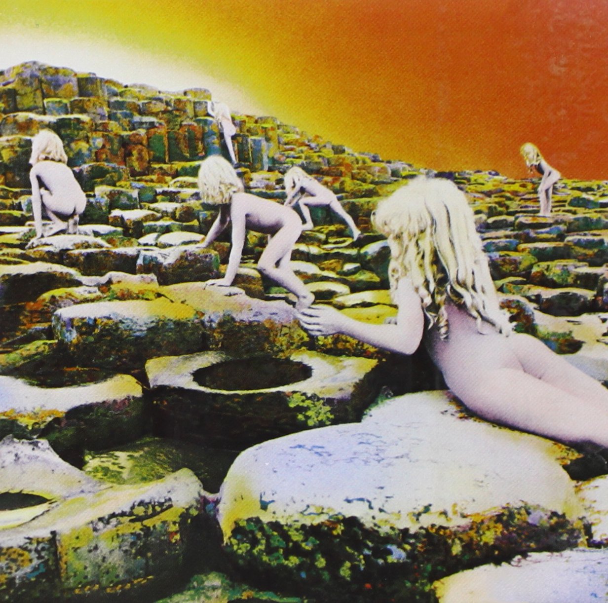 Nude children climb a rocky, otherworldly landscape under a yellow sky.