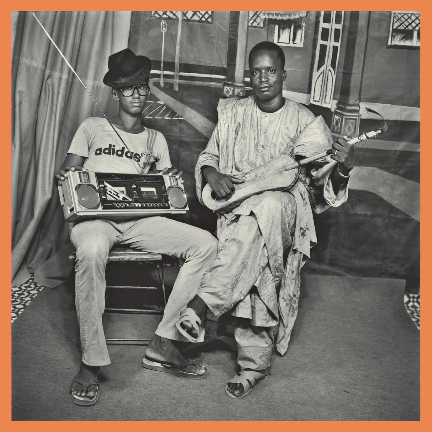 Black and white photo of two men with a boombox and guitar.