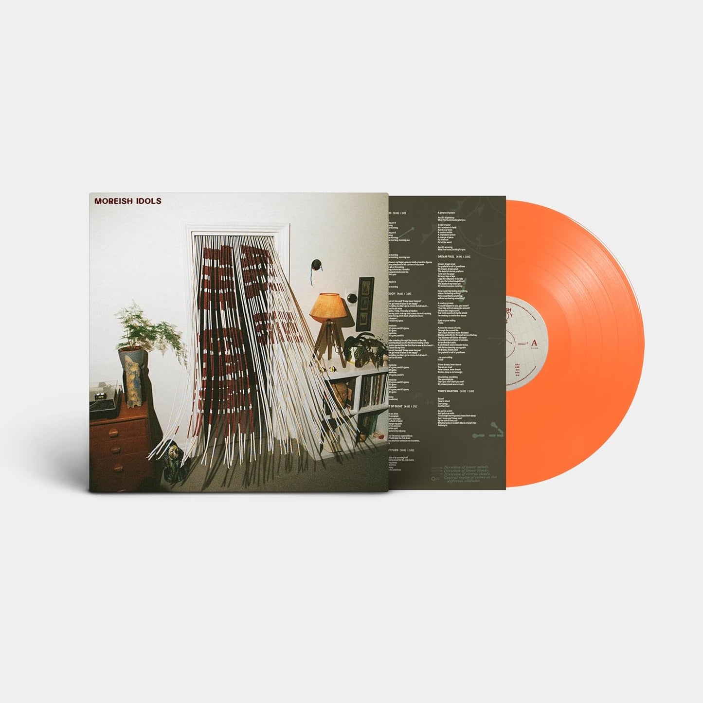 Vinyl record with orange disc and cover featuring a room interior.