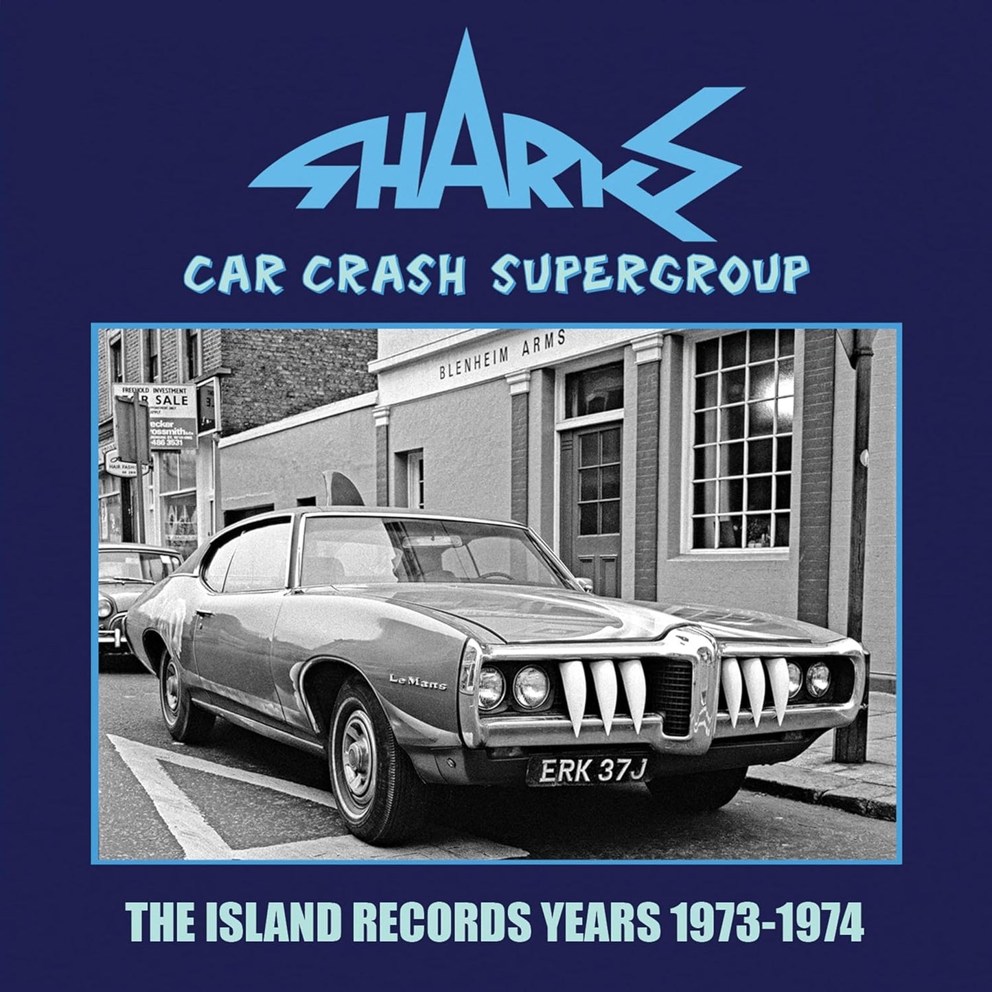 CD cover: black and white photo of a damaged car in front of buildings.