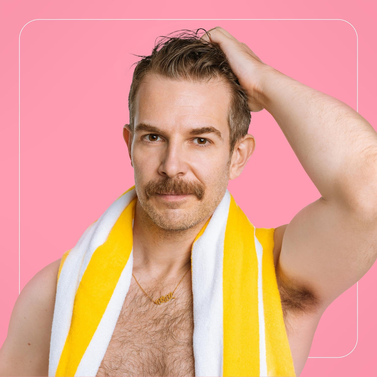 Man with mustache and towel draped around neck, pink background.