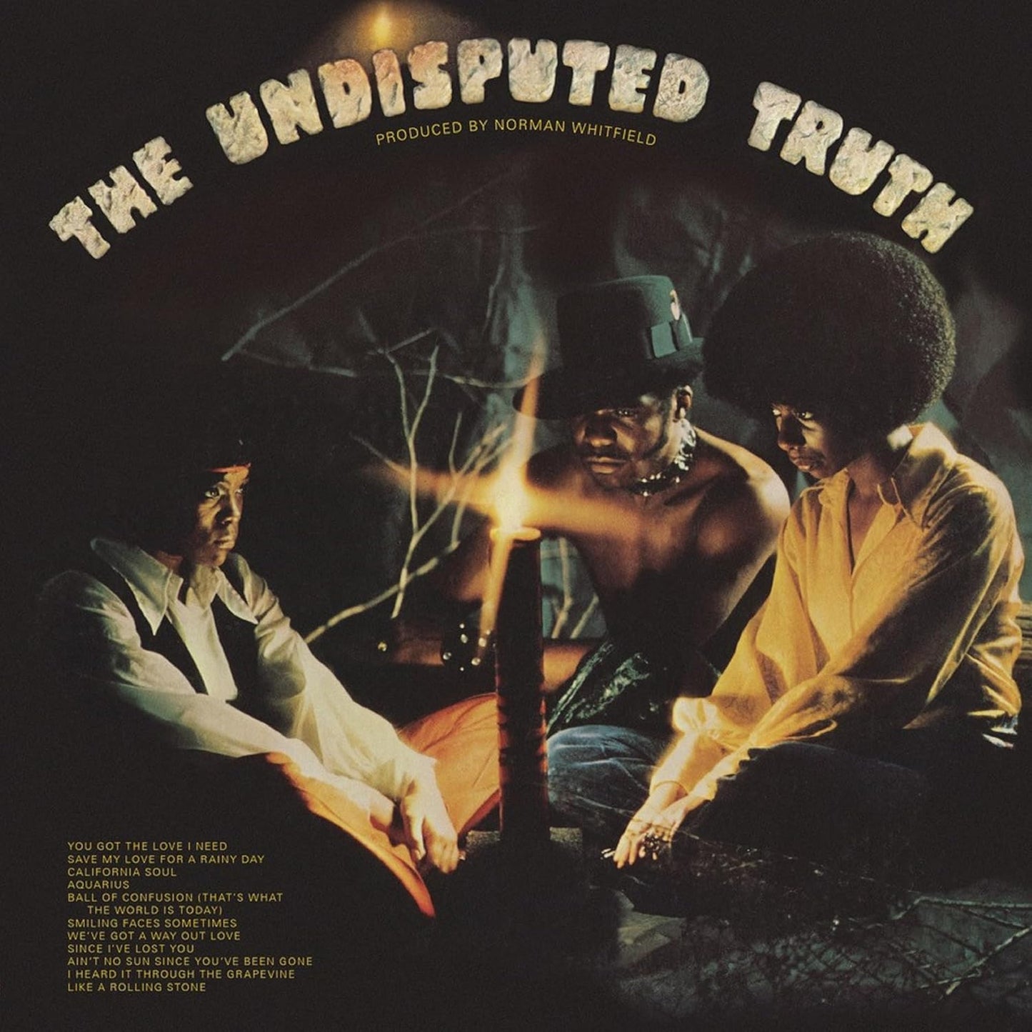 Vinyl album cover featuring three people illuminated by a candle in a dark forest.