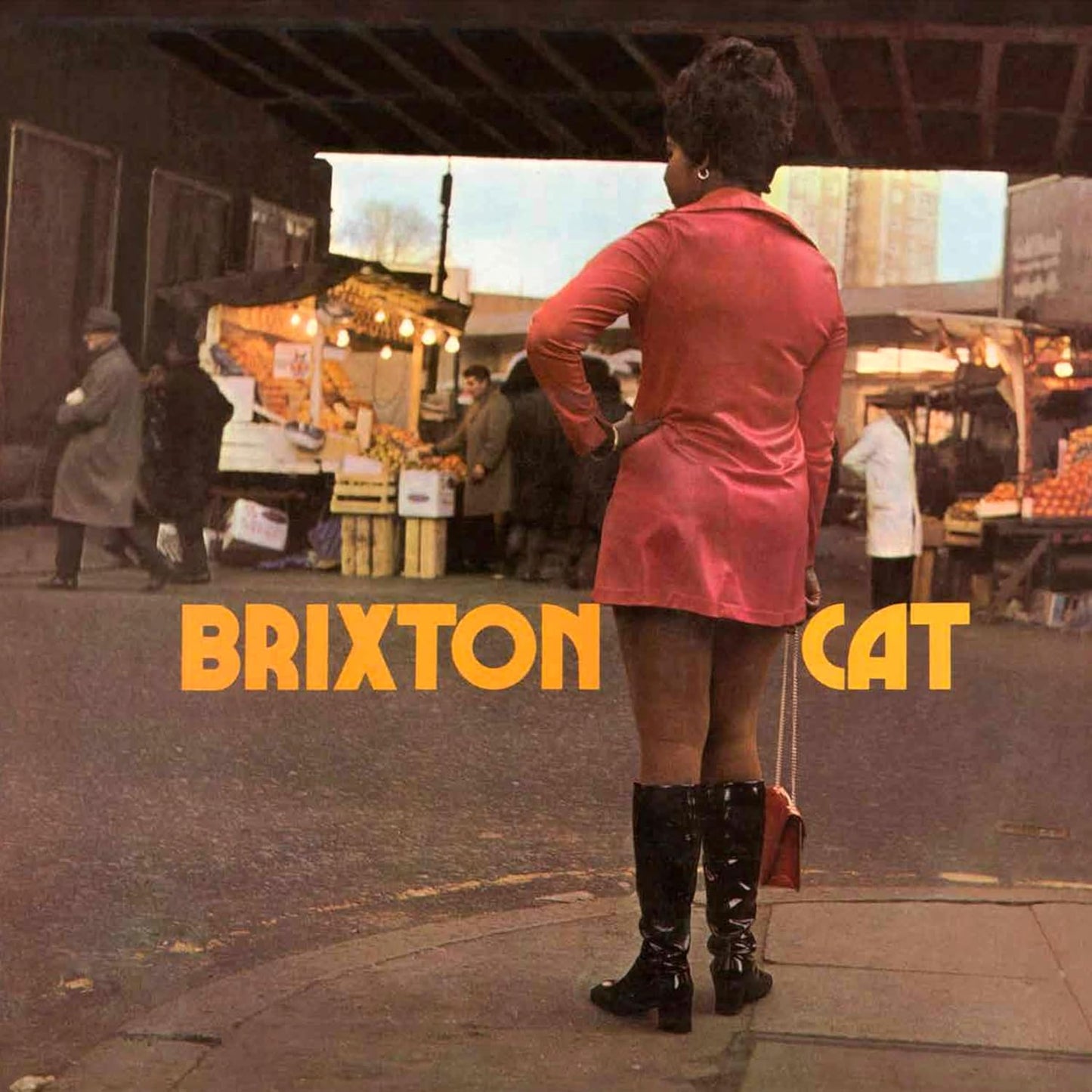 Album cover for “Brixton Cat” featuring a person and market scene.