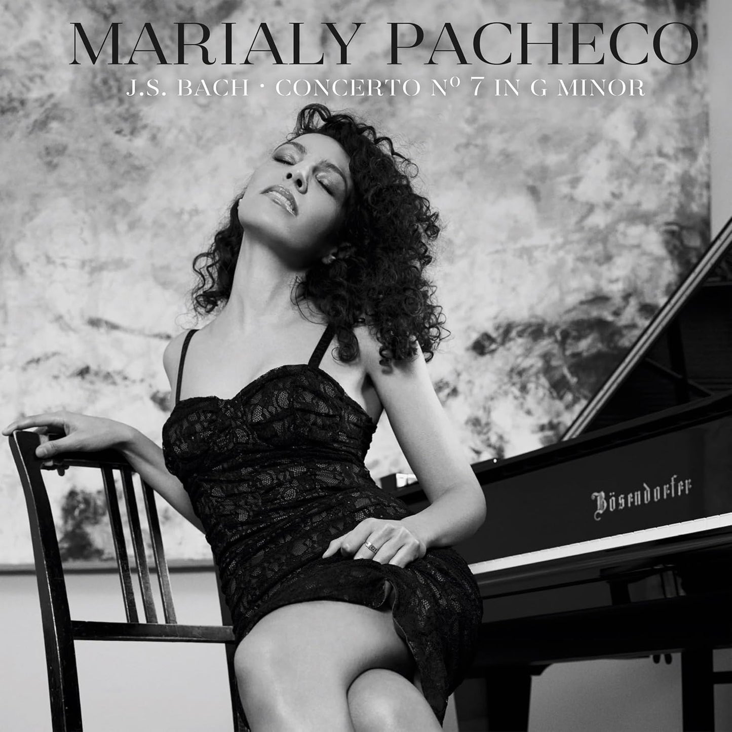 Black and white portrait of Marialy Pacheco with a grand piano.