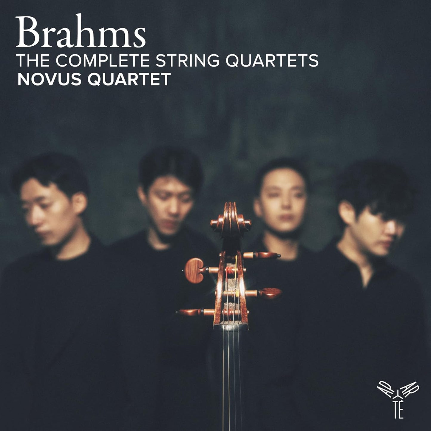 The Novus Quartet members stand behind the neck of a cello on a dark background.