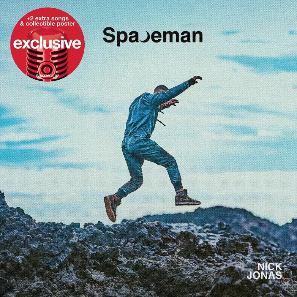Nick Jonas jumping over rocky terrain against a blue sky on the Spaceman album cover.