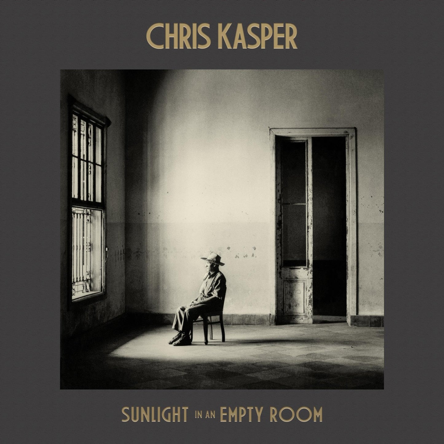 CD cover: man sitting in a sunlit, empty room with a window.