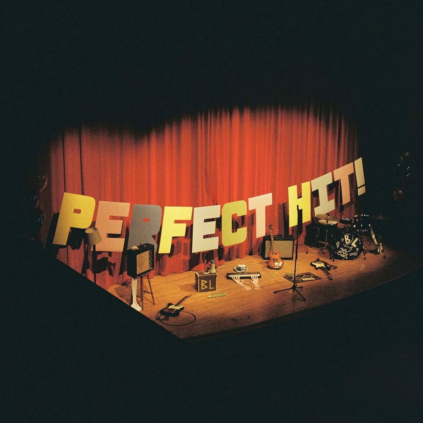 Stage setup with instruments and large letters spelling "PERFECT HIT!".