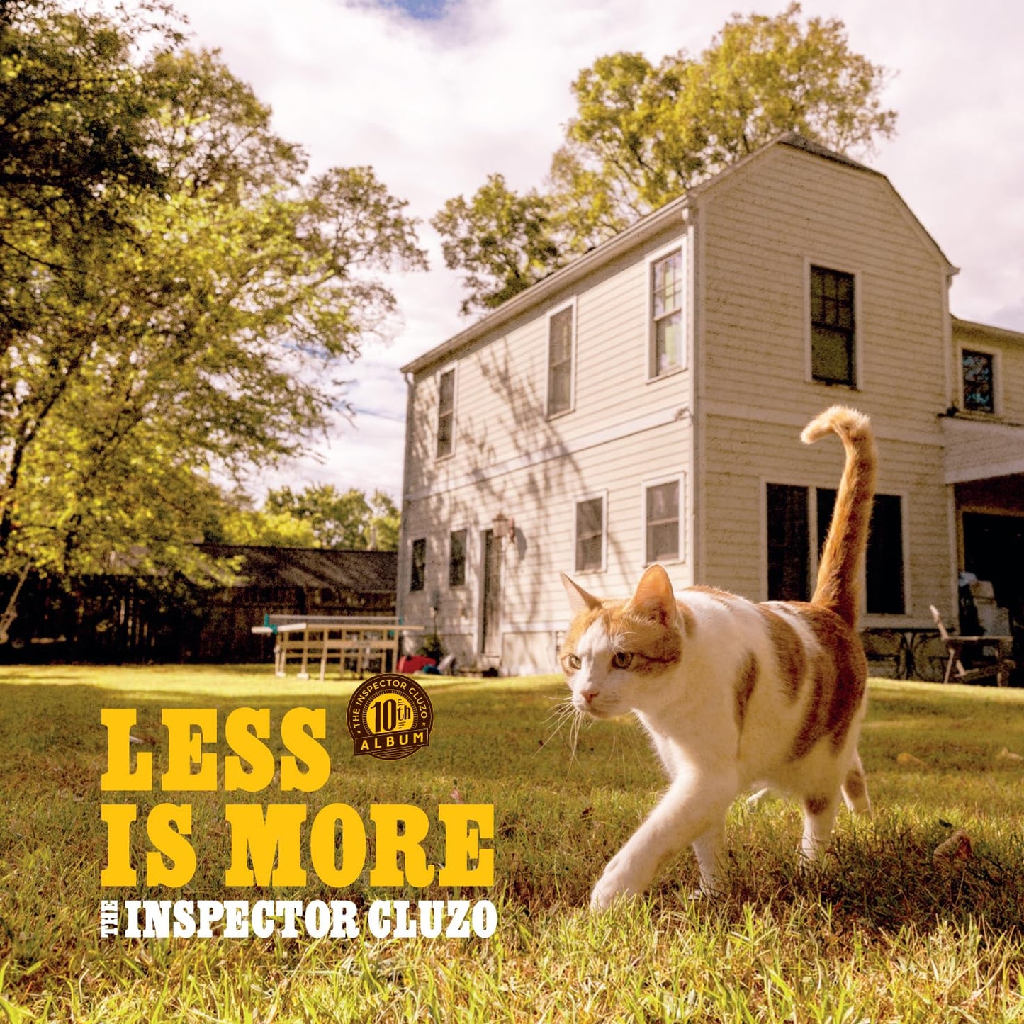 Album cover: orange background, cat running, and a white farmhouse.