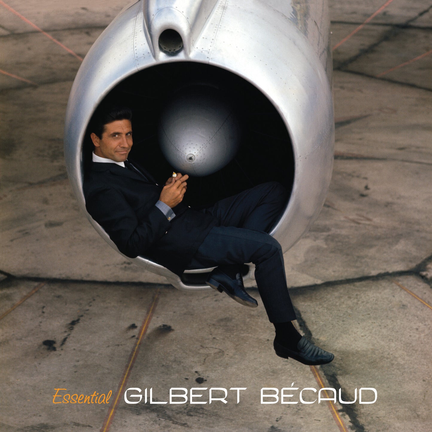 Gilbert Bécaud in a suit, posed inside a jet engine’s intake.