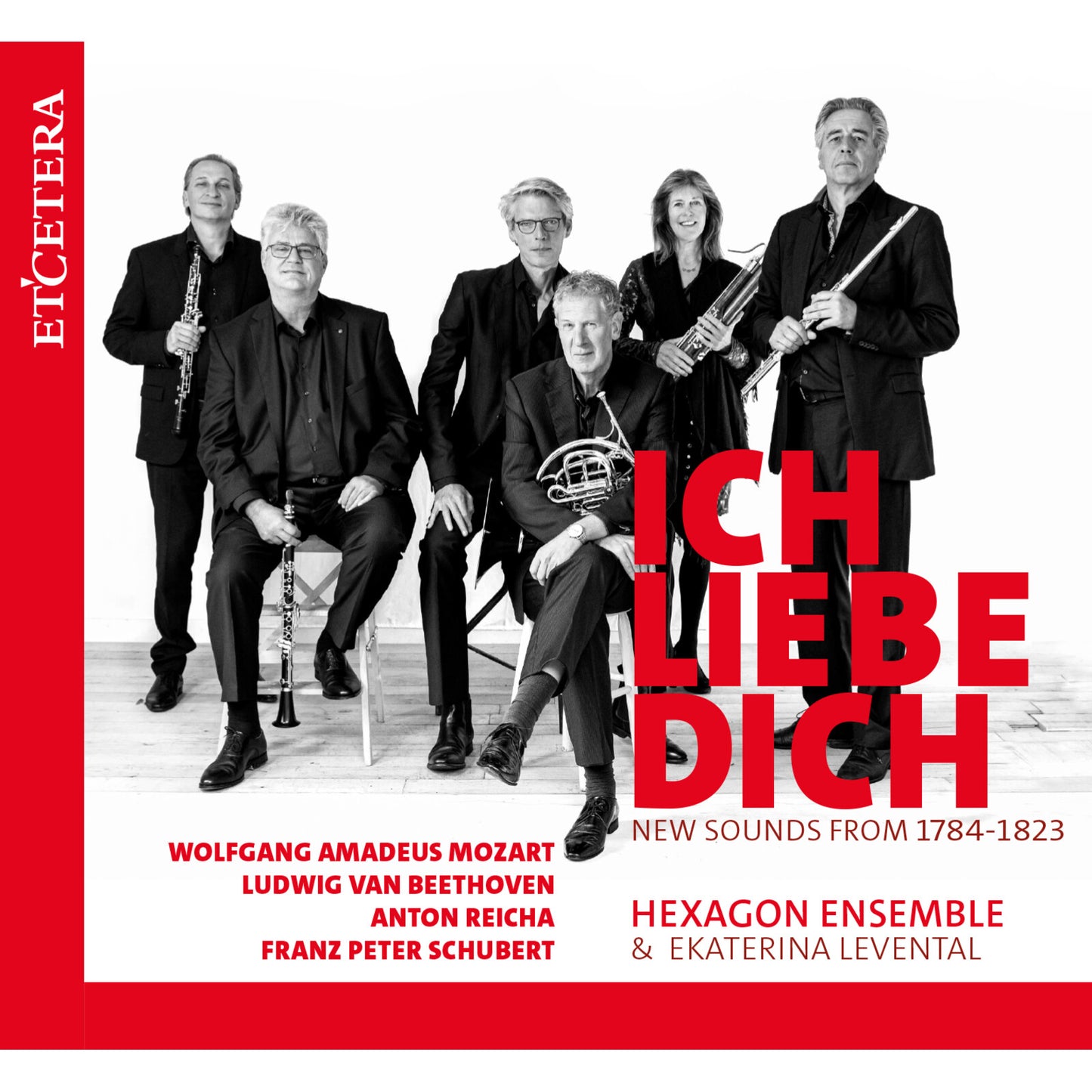 Six musicians with instruments pose in front of a red and white background.