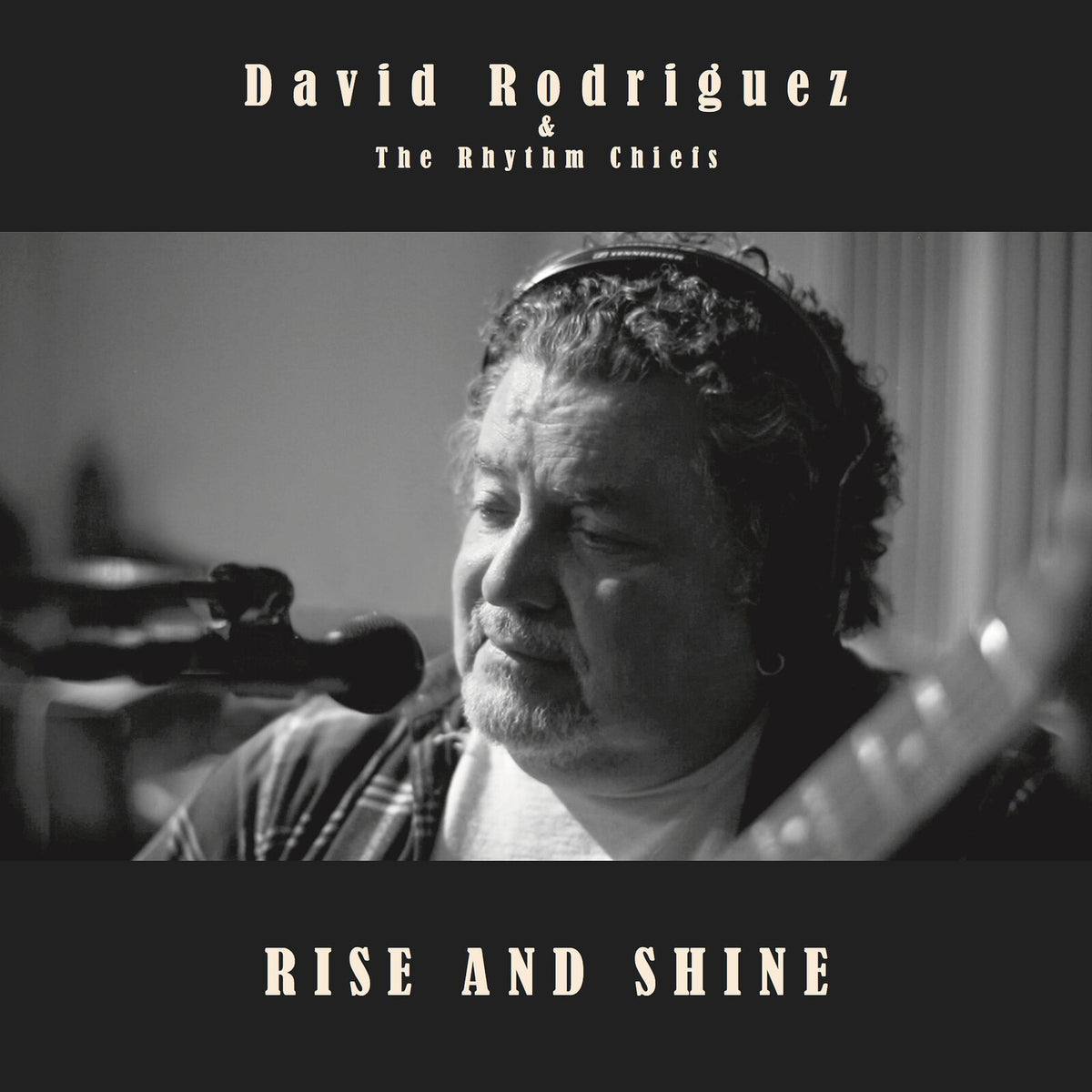 Black and white album cover featuring a man with headphones and guitar.