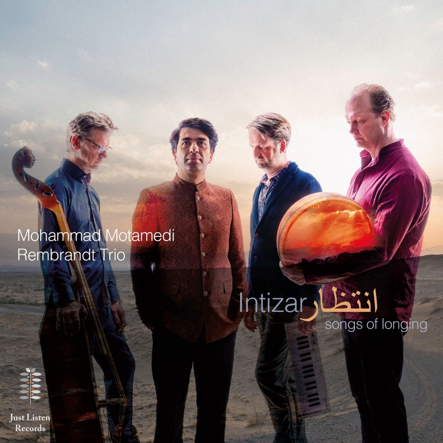 Four musicians with instruments stand against a desert landscape.