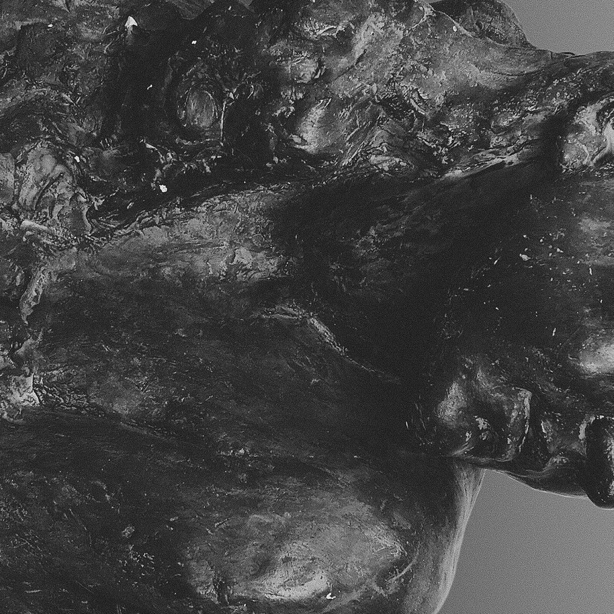 Close-up of textured, grayscale abstract sculpture resembling human forms.