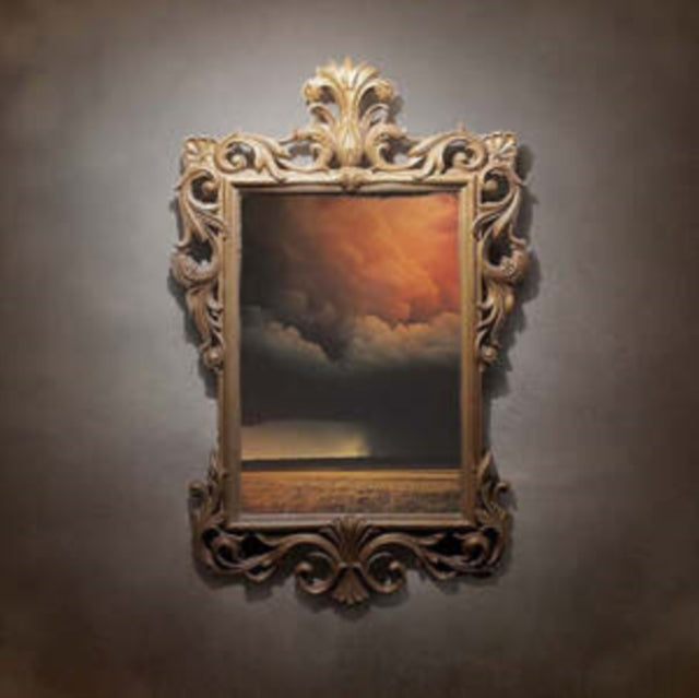 Ornate gold frame surrounding a dark, cloudy landscape painting.