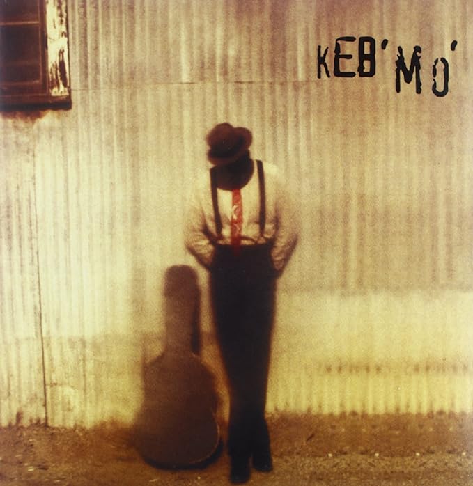 Album cover for Keb Mo featuring a man with a guitar shadow.