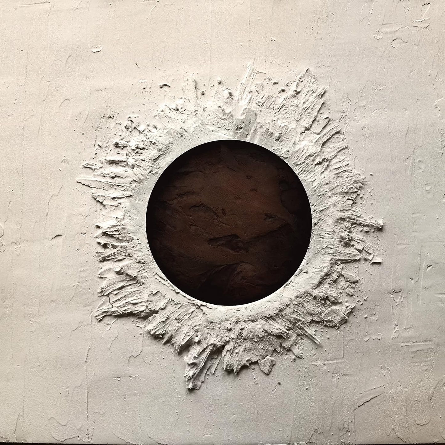 White textured wall with a dark circular hole in the center.