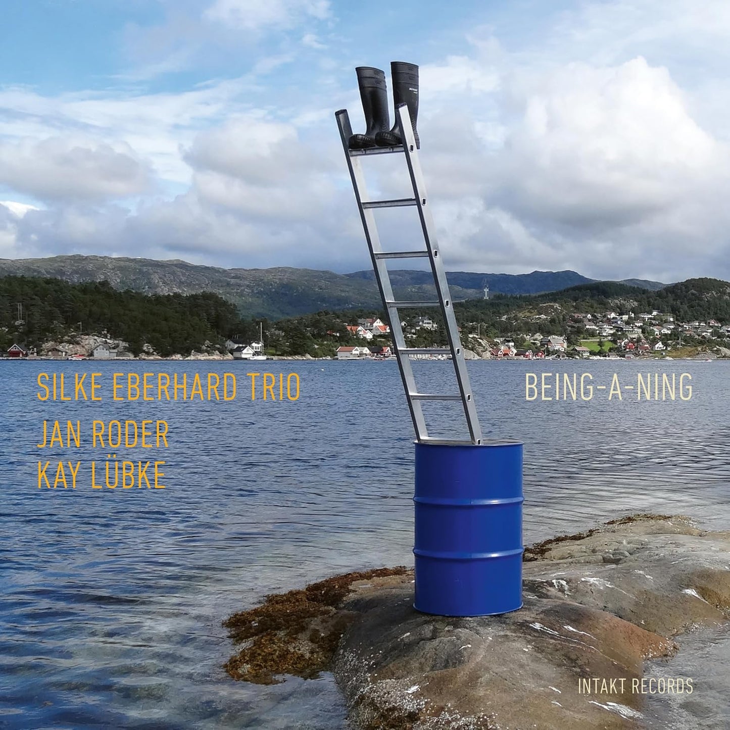 CD cover with a ladder on a blue barrel by the sea.