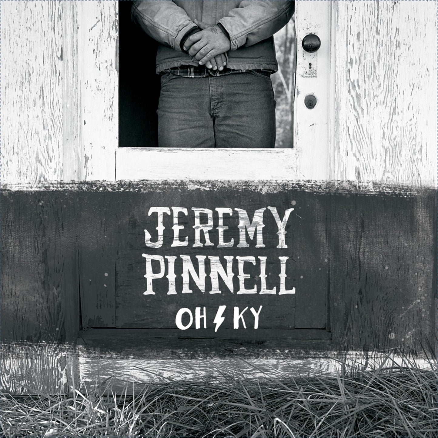 Black and white album cover featuring a man in a doorway and text.