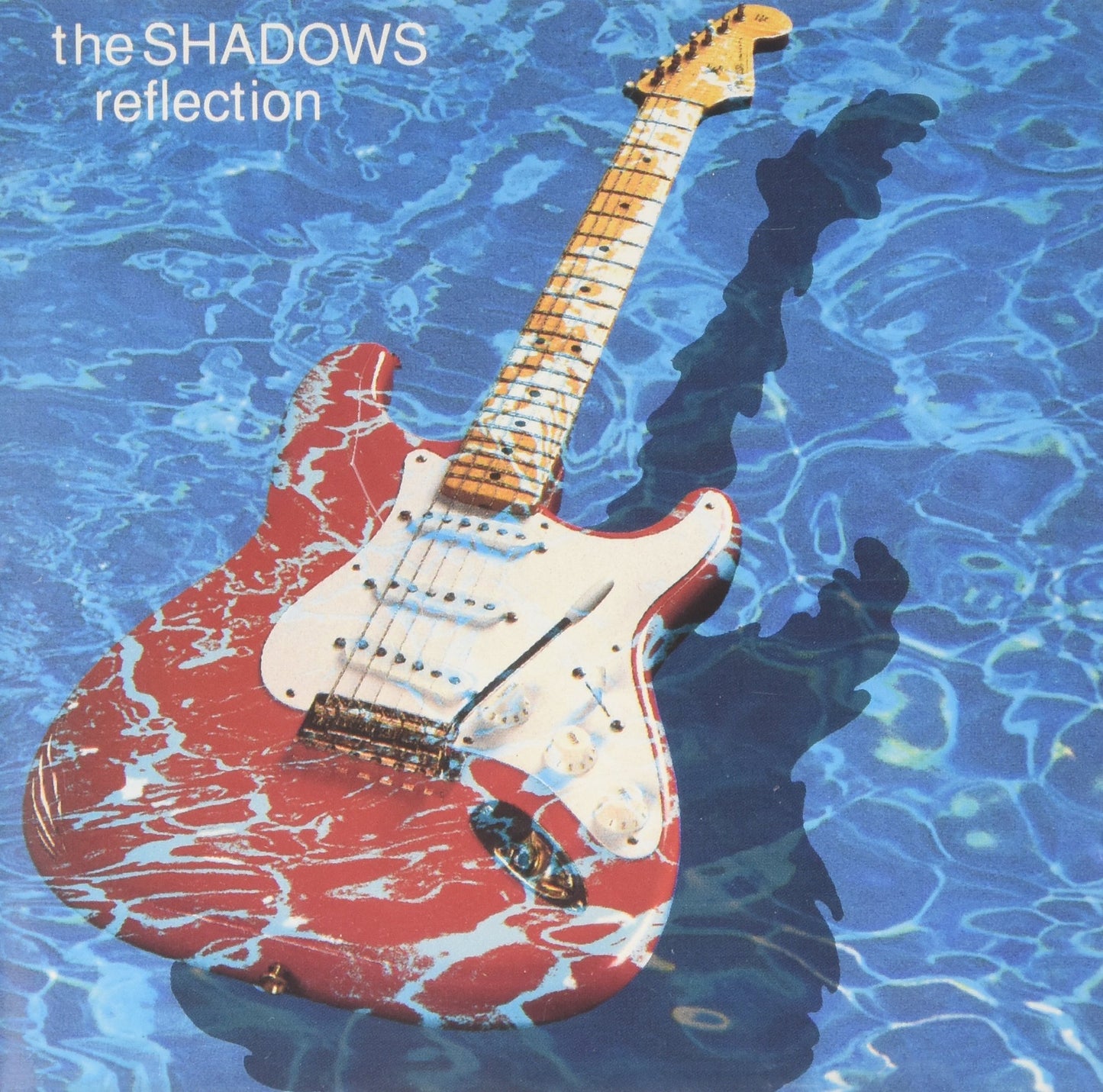 Red and white electric guitar partially submerged in blue water.