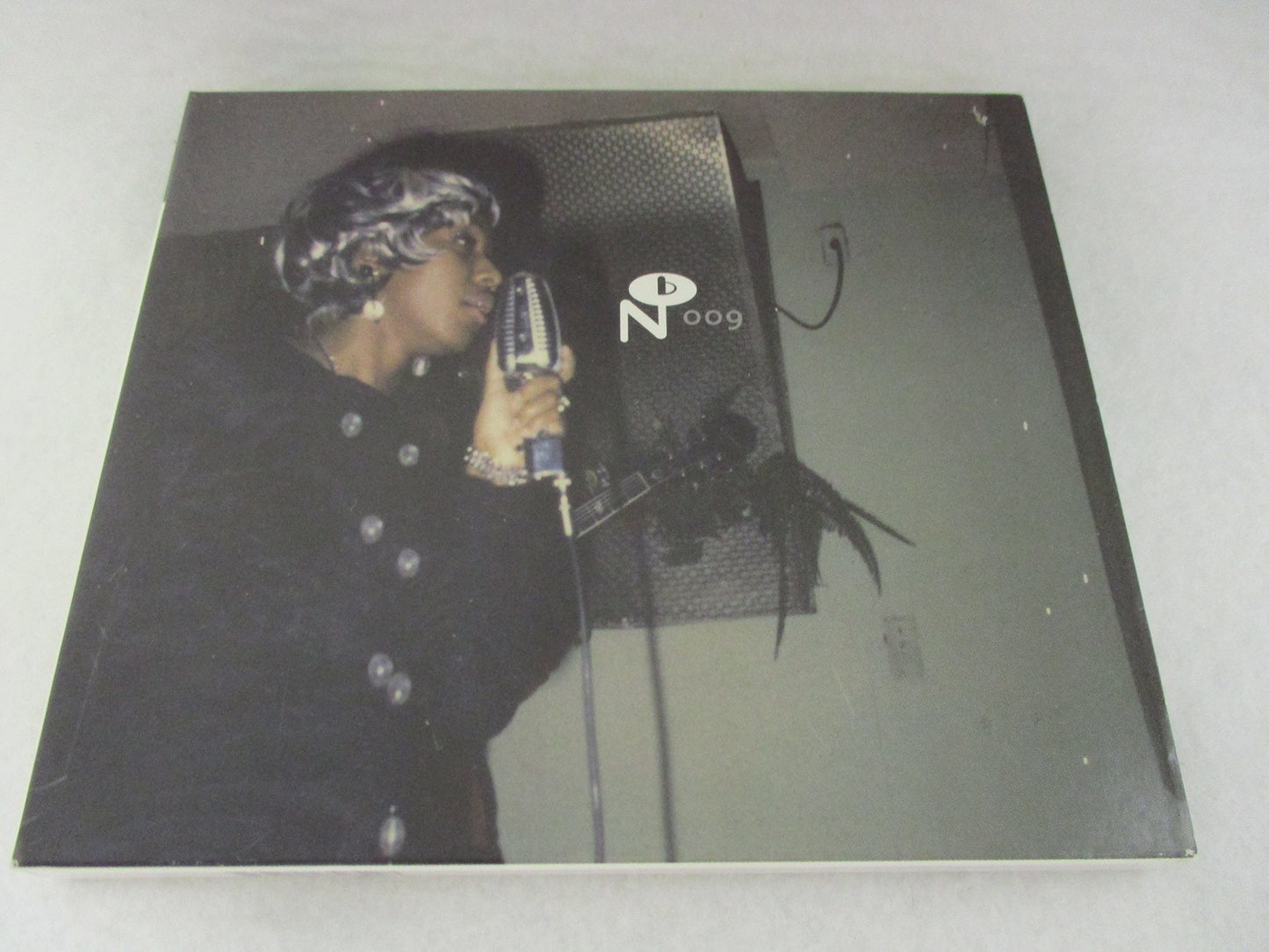 CD case featuring a black and white photo of a singer at a microphone.