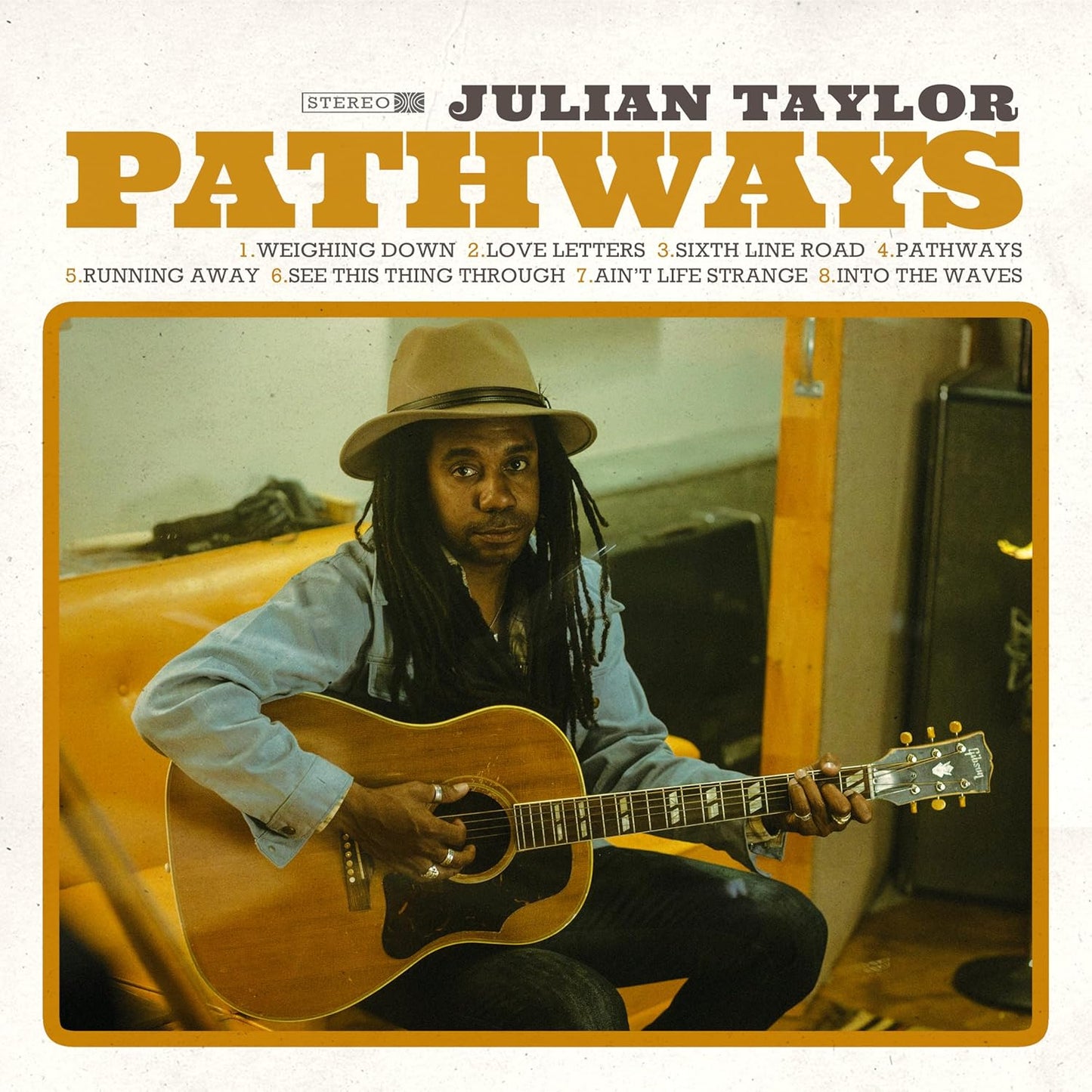 Album cover for Julian Taylor’s “Pathways” featuring a portrait of the artist with a guitar.