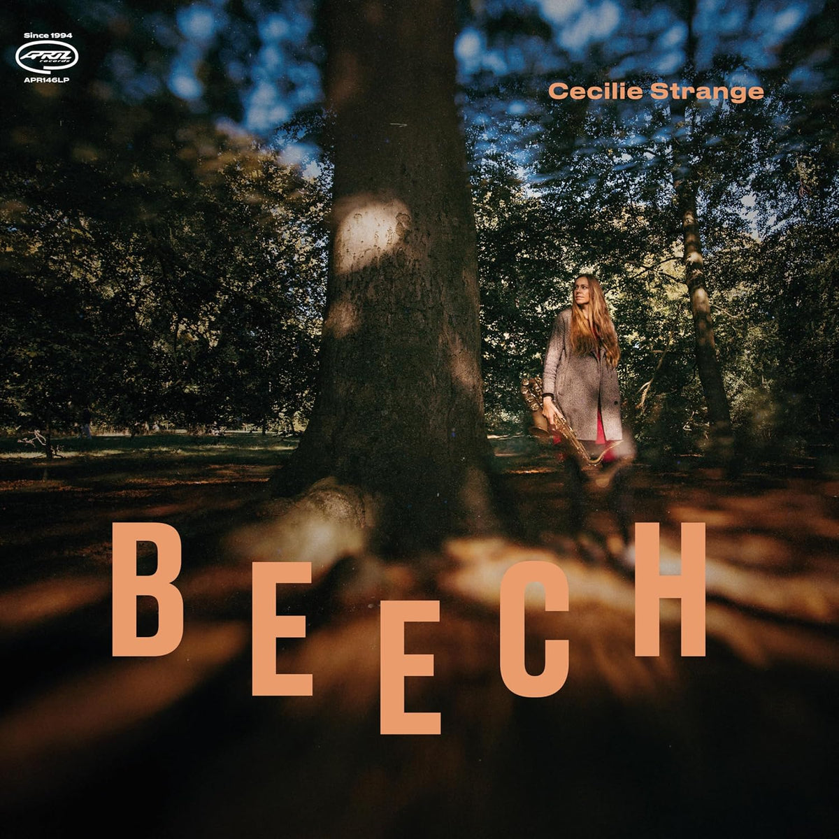 Album cover: Cecilie Strange stands with a saxophone in a forest.