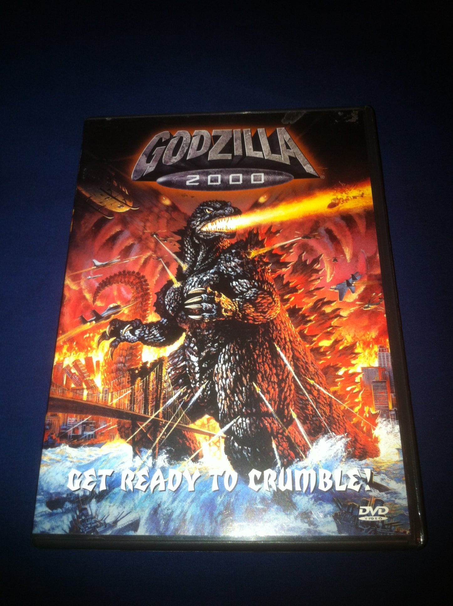 Godzilla 2000 DVD cover featuring the monster amidst a fiery cityscape.
