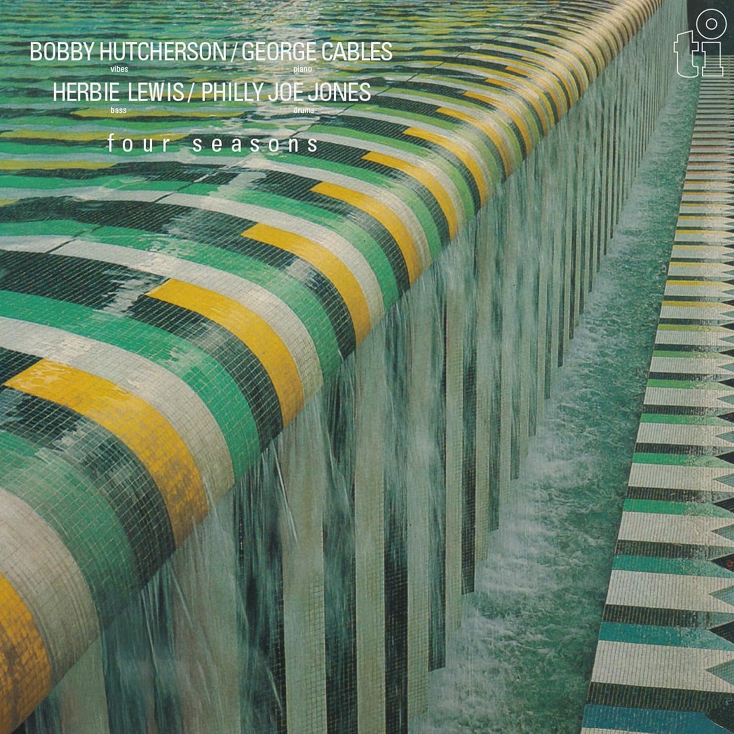 Water flows over a tiled pool edge with green, yellow, and white patterns.