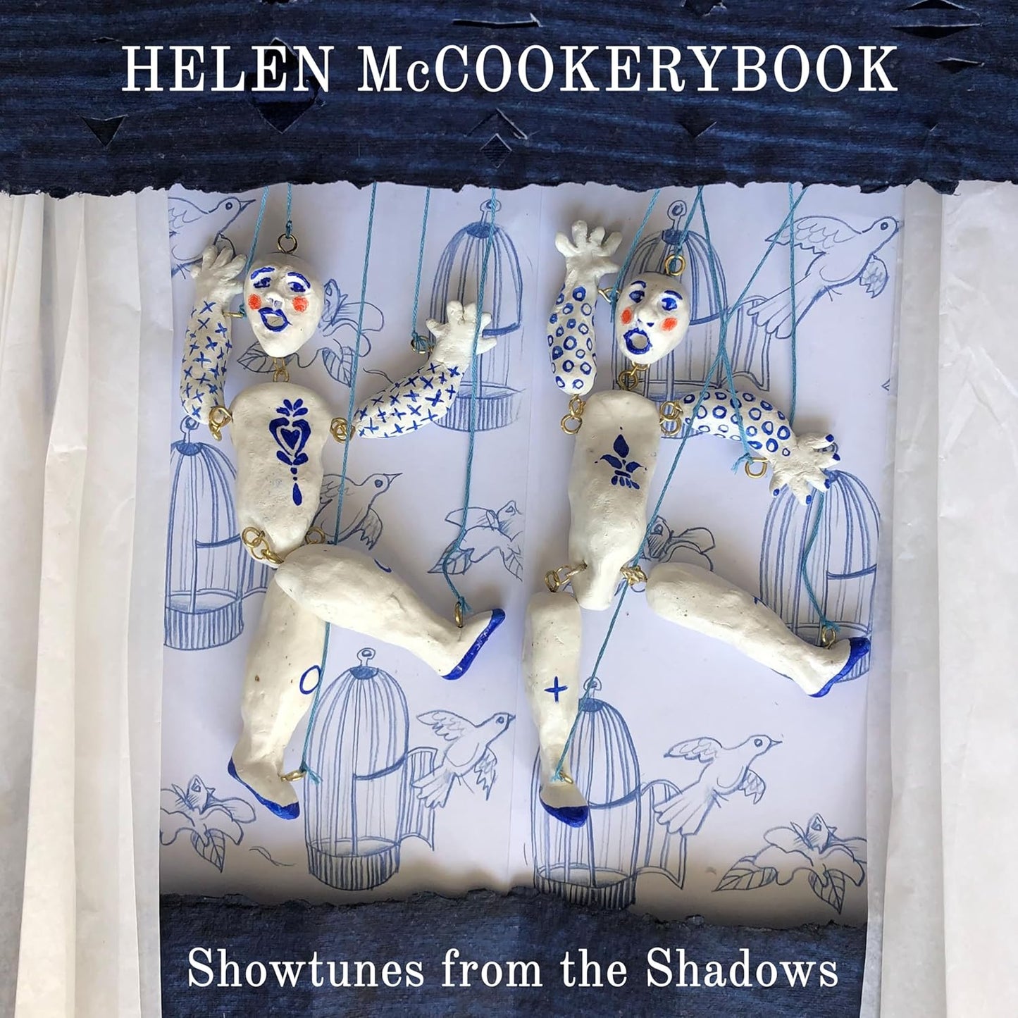 Album cover for "Showtunes From The Shadows" featuring sculpted figures and birds.