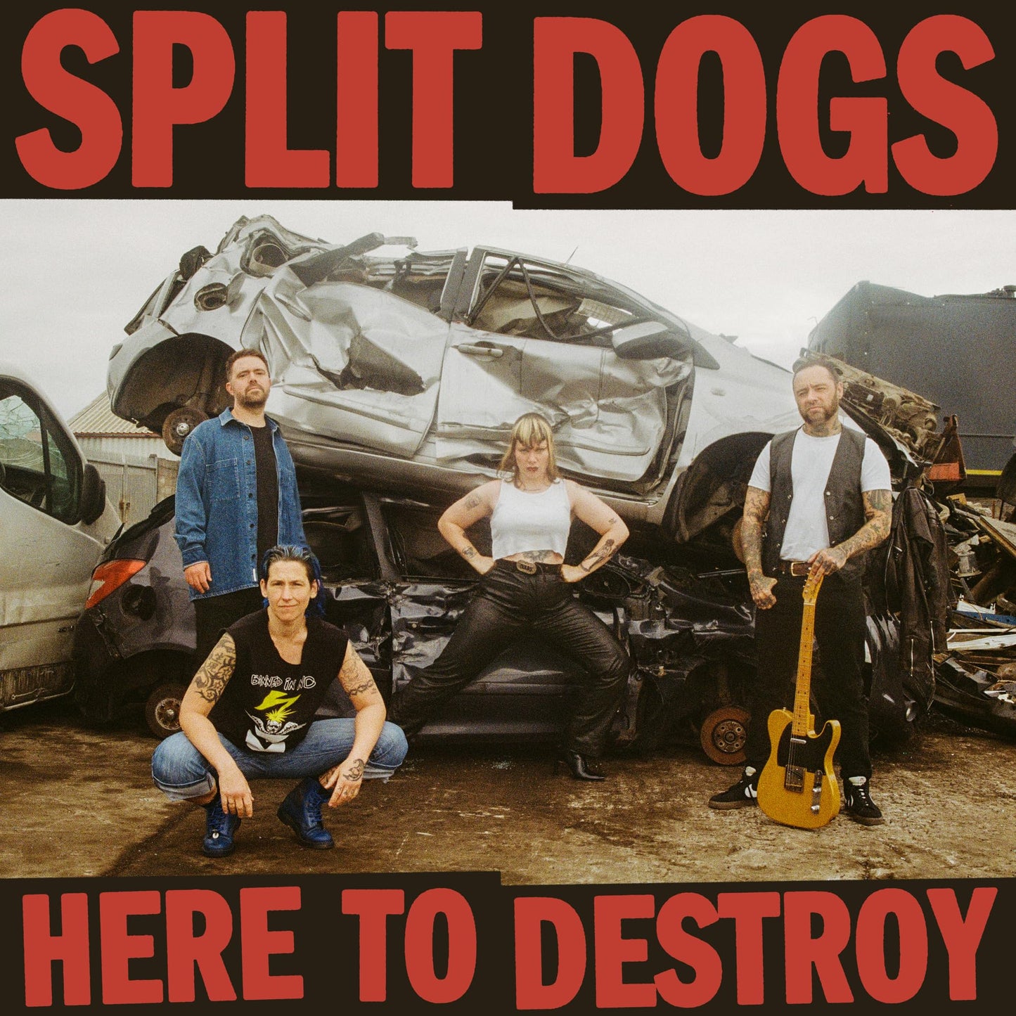 CD cover: band posing in front of a crushed car wreck.
