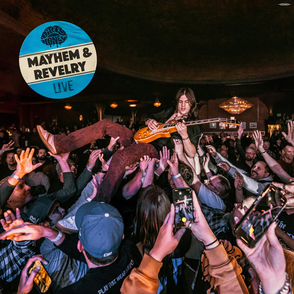 Guitarist crowd-surfs during a live concert, hands reaching up from the audience.