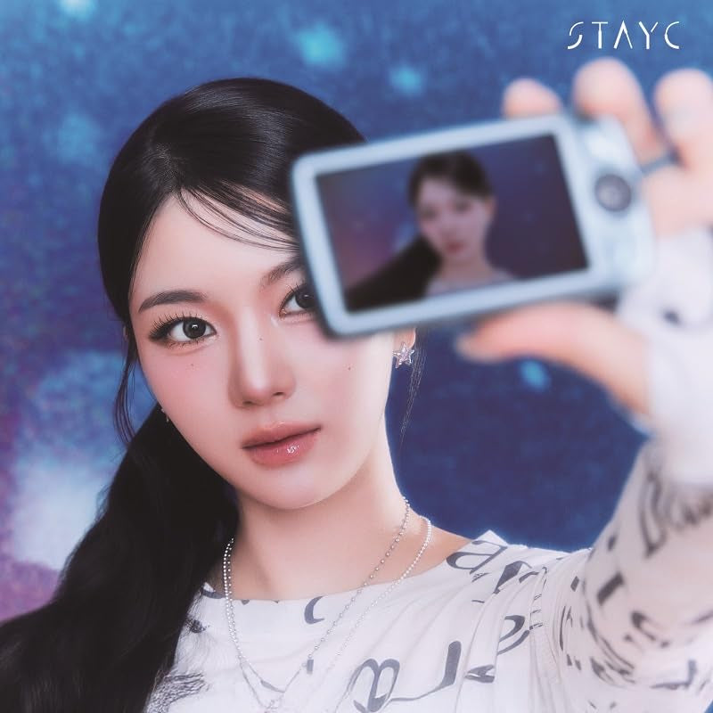Stayc member holding a phone displaying another member’s image.
