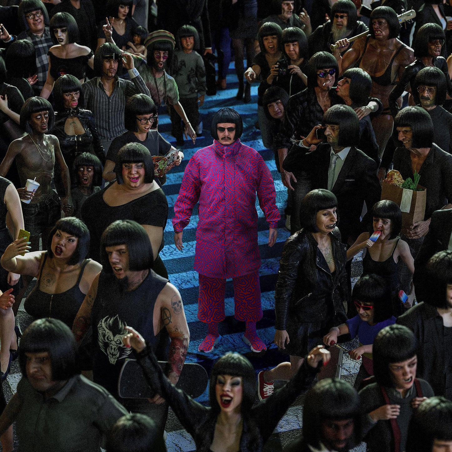 Oliver Tree in a patterned red and blue suit standing amidst a crowd.