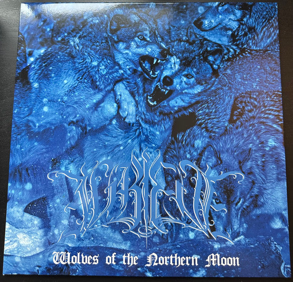 Blue vinyl record cover with howling wolves and ornate band logo.