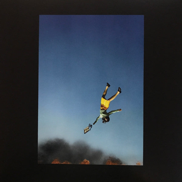 Person falling from sky, holding a cassette tape, against blue.