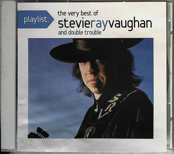 CD case featuring Stevie Ray Vaughan in a hat, against a blue sky.