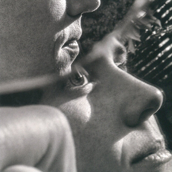 Black and white close-up of two faces nearly touching.