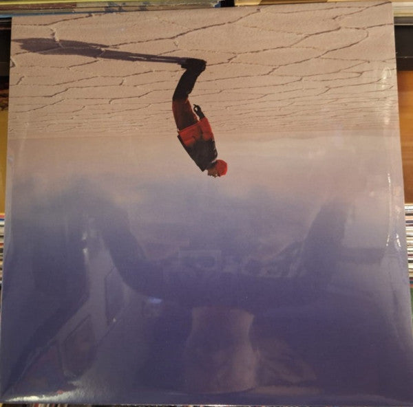 Vinyl record cover featuring a person falling against a cloudy sky.
