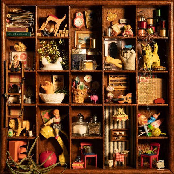 Wooden cabinet filled with small, vintage toys and objects.