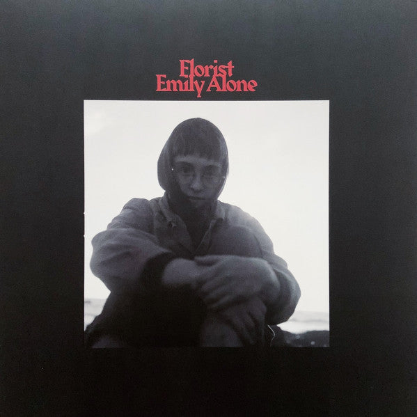 Black and white portrait of a person with short hair, album cover.