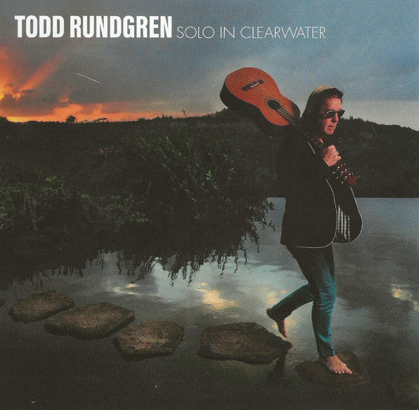Todd Rundgren album cover: man with guitar by water at sunset.