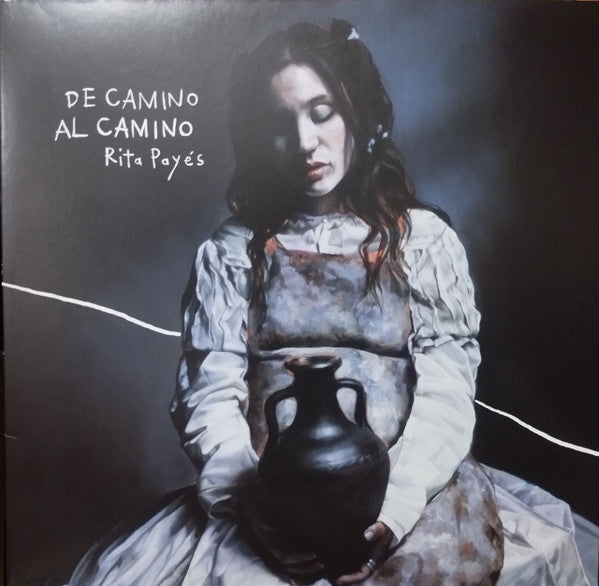 Album cover: Rita Payés portrait, holding a clay pot, dark background.